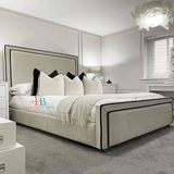 cream bedframe with black border and mattress